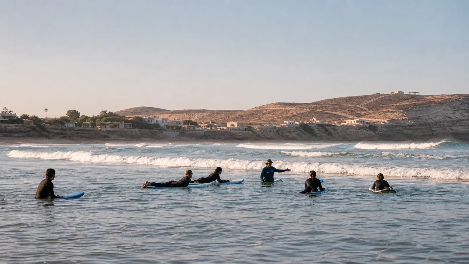Beginner surfers practicing in gentle morning waves on Morocco's Atlantic coast